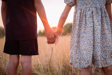 Çocuk silueti, çocuğun sevinç anları. Doğanın günbatımında yumuşak ve bulanık arka planda