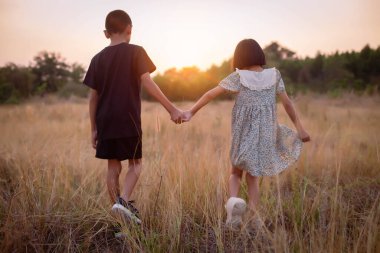 Çocuk silueti, çocuğun sevinç anları. Doğanın günbatımında yumuşak ve bulanık arka planda