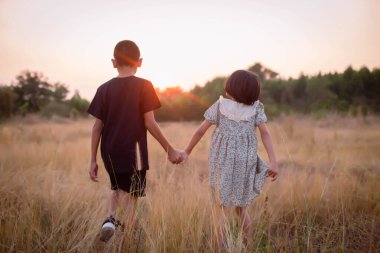 Çocuk silueti, çocuğun sevinç anları. Doğanın günbatımında yumuşak ve bulanık arka planda