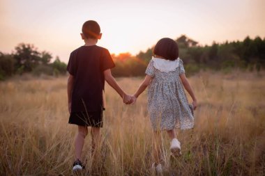 Çocuk silueti, çocuğun sevinç anları. Doğanın günbatımında yumuşak ve bulanık arka planda