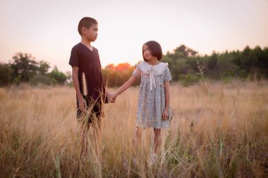 Çocuk silueti, çocuğun sevinç anları. Doğanın günbatımında yumuşak ve bulanık arka planda