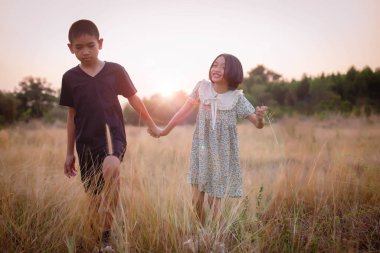 Çocuk silueti, çocuğun sevinç anları. Doğanın günbatımında yumuşak ve bulanık arka planda
