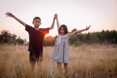 Çocuk silueti, çocuğun sevinç anları. Doğanın günbatımında yumuşak ve bulanık arka planda