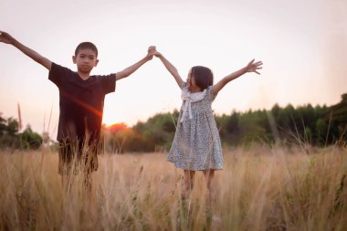 Çocuk silueti, çocuğun sevinç anları. Doğanın günbatımında yumuşak ve bulanık arka planda