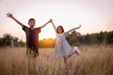 Çocuk silueti, çocuğun sevinç anları. Doğanın günbatımında yumuşak ve bulanık arka planda