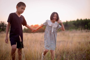 Çocuk silueti, çocuğun sevinç anları. Doğanın günbatımında yumuşak ve bulanık arka planda