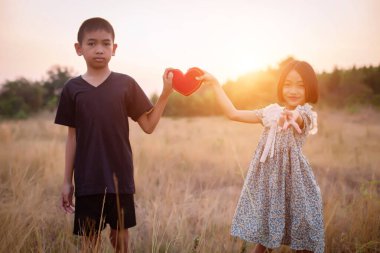 Çocuk silueti, çocuğun sevinç anları. Doğanın günbatımında yumuşak ve bulanık arka planda