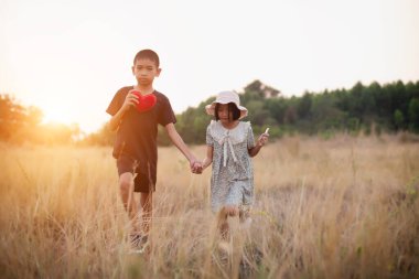 Çocuk silueti, çocuğun sevinç anları. Doğanın günbatımında yumuşak ve bulanık arka planda