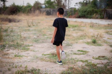 Siyah tişörtlü çocuk tek başına yürüdü..