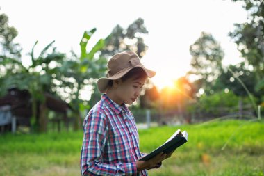 Yeşil çimenlerin üzerinde uzanan mutlu kadın parkta kitap okuyor (açık havada) SSTKHome