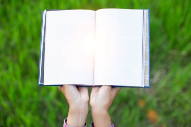 Yeşil çimenlerin üzerinde uzanan mutlu kadın parkta kitap okuyor (açık havada) SSTKHome