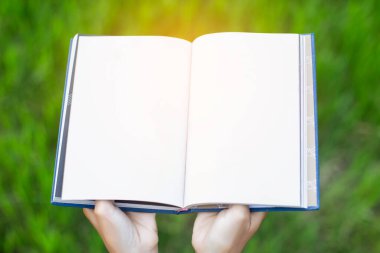Yeşil çimenlerin üzerinde uzanan mutlu kadın parkta kitap okuyor (açık havada) SSTKHome