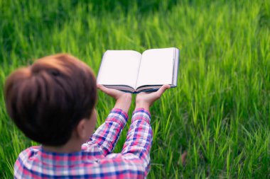 Yeşil çimenlerin üzerinde uzanan mutlu kadın parkta kitap okuyor (açık havada) SSTKHome