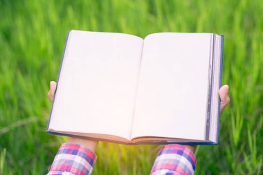 Yeşil çimenlerin üzerinde uzanan mutlu kadın parkta kitap okuyor (açık havada) SSTKHome