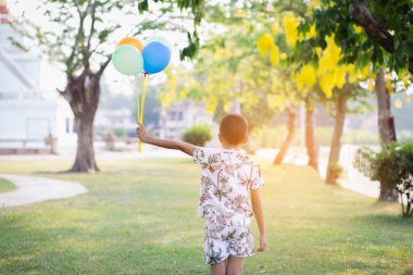 Bahar parkında balonlu mutlu çocuk.