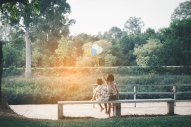 Çocuklar yazın güneşli bahçede oynarlar.