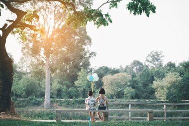 Çocuklar yazın güneşli bahçede oynarlar.