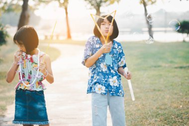 Sabun köpüğü üfleyen neşeli bir kızın portresi