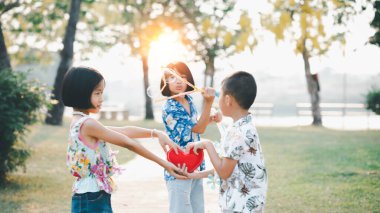 Sevgililer gününde kırmızı kalp şeklinde bir oyuncak tutan mutlu küçük kız.