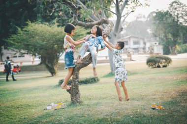 Çocuklar yazın güneşli bahçede oynarlar.