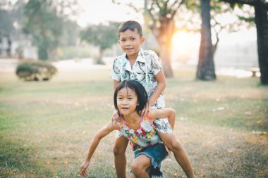 Çocuklar yazın güneşli bahçede oynarlar.