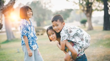 Çocuklar yazın güneşli bahçede oynarlar.