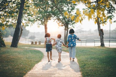Çocuklar yazın güneşli bahçede oynarlar.