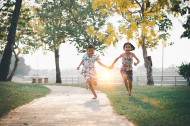 Çocuklar yazın güneşli bahçede oynarlar.