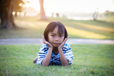 Dışarıda yalnız oturan üzgün küçük bir kız.