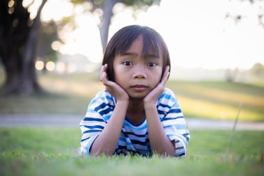 Dışarıda yalnız oturan üzgün küçük bir kız.