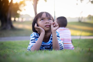 Dışarıda yalnız oturan üzgün küçük bir kız.