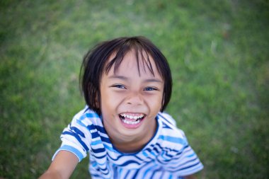 Dışarıda yalnız oturan üzgün küçük bir kız.