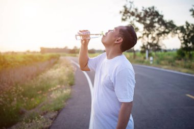 Su şişeli adam dışarıda egzersiz molası veriyor.