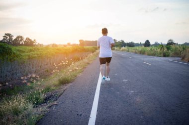 şehir parkında koşu yolu üzerinde çalışan genç adam Runner