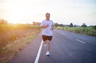 şehir parkında koşu yolu üzerinde çalışan genç adam Runner