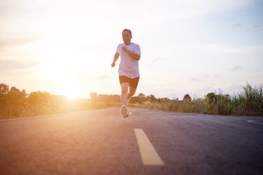 şehir parkında koşu yolu üzerinde çalışan genç adam Runner