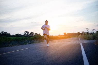 şehir parkında koşu yolu üzerinde çalışan genç adam Runner