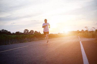 şehir parkında koşu yolu üzerinde çalışan genç adam Runner