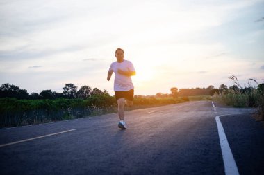 şehir parkında koşu yolu üzerinde çalışan genç adam Runner