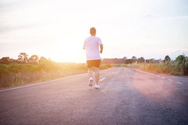 şehir parkında koşu yolu üzerinde çalışan genç adam Runner