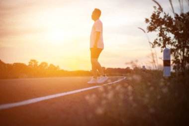 şehir parkında koşu yolu üzerinde çalışan genç adam Runner