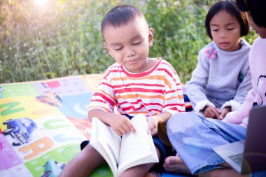 Çocuklar büyüteçle ormanda keşfe çıkıyorlar.