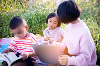 Çocuklar büyüteçle ormanda keşfe çıkıyorlar.