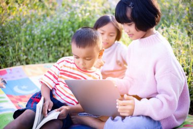 Çocuklar büyüteçle ormanda keşfe çıkıyorlar.