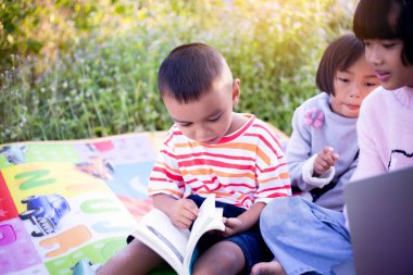 Çocuklar büyüteçle ormanda keşfe çıkıyorlar.