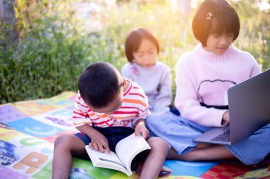 Çocuklar büyüteçle ormanda keşfe çıkıyorlar.