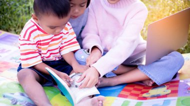 Çocuklar büyüteçle ormanda keşfe çıkıyorlar.