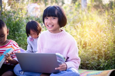 Çocuklar büyüteçle ormanda keşfe çıkıyorlar.