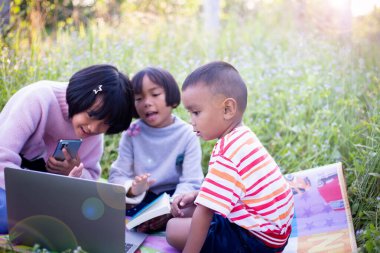 Çocuklar büyüteçle ormanda keşfe çıkıyorlar.