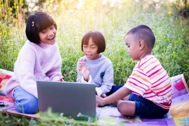 Çocuklar büyüteçle ormanda keşfe çıkıyorlar.